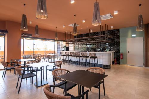 a restaurant with tables and chairs and a counter at Kiani Beach Resort Family All Inclusive in Kalyves