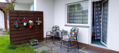 two chairs and a table outside of a house at Landhotel Jägerhof in Bischofsgrün