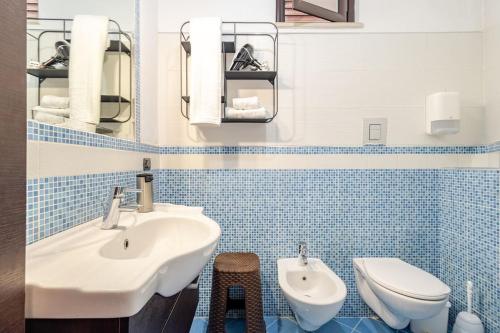 a blue tiled bathroom with a sink and a toilet at The old man and the sea in Marina di Palma