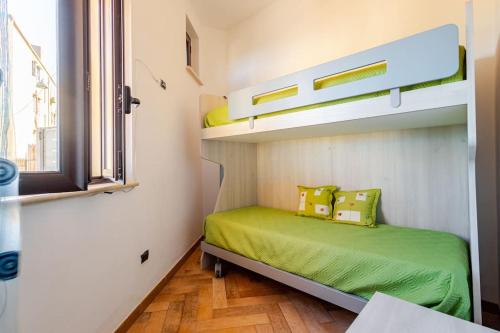 a small bedroom with a bunk bed with green sheets at The old man and the sea in Marina di Palma