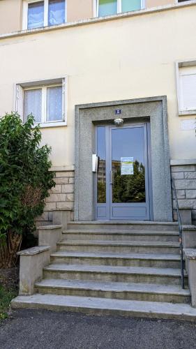 a door to a building with stairs in front at Balcon du Cube in Saint-André-les-Vergers