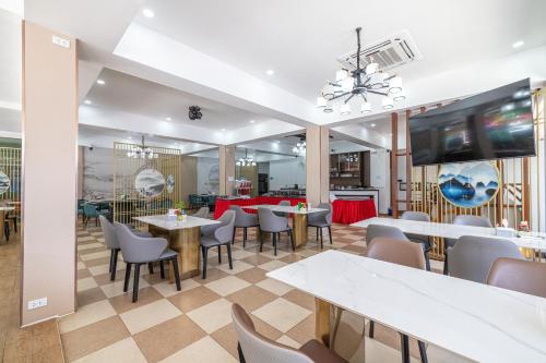 un ristorante con tavoli, sedie e una televisione di Phuket Meet Holiday Hotel-Rawai 普吉岛相遇花园度假酒店-拉威店 a Rawai Beach