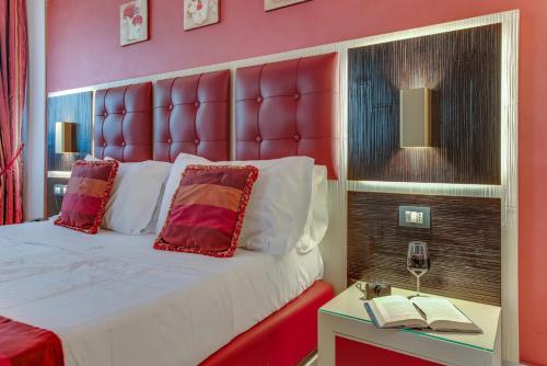 a bedroom with a large bed with a red headboard at Fazio Rooms in Sciacca