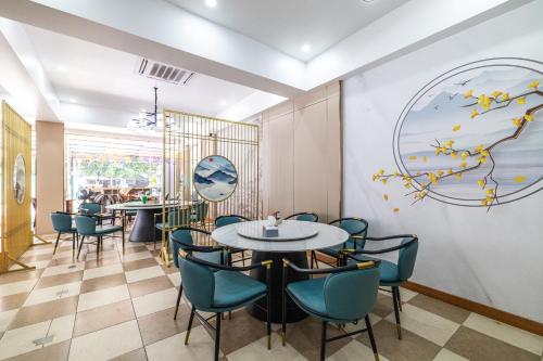 un ristorante con tavoli e sedie e un dipinto sul muro di Phuket Meet Holiday Hotel-Rawai 普吉岛相遇花园度假酒店-拉威店 a Rawai Beach