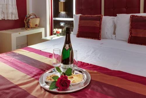 a bottle of champagne and a plate of food on a bed at Fazio Rooms in Sciacca