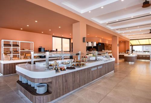 a restaurant with a counter with food on it at Kiani Beach Resort Family All Inclusive in Kalyves