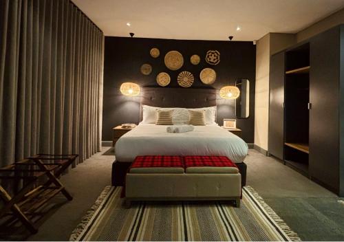 a bedroom with a large bed and a red bench at Blix Inn Guesthouse in Stellenbosch