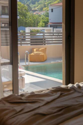 a view of a swimming pool from a bedroom window at Ntinas Seaside Suites in Skala Potamias