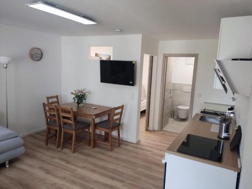a kitchen and a dining room with a table and chairs at Ferienwohnung Heimelig in Kappel-Grafenhausen
