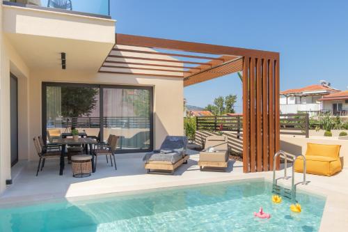 a house with a swimming pool and a patio at Ntinas Seaside Suites in Skala Potamias