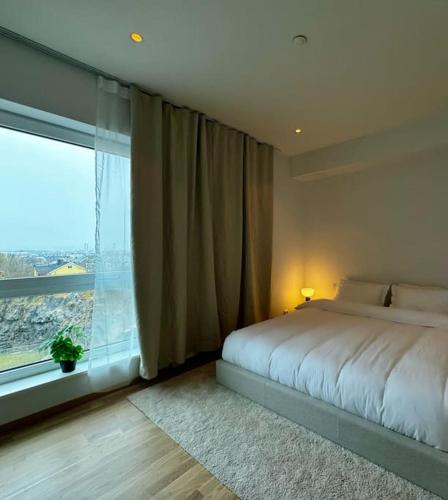 a bedroom with a bed and a large window at Central Apartment in Bodø with ocean view in Bodø