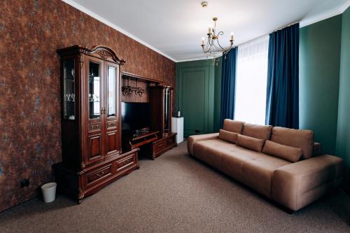 a living room with a couch and a cabinet at Globus Hotel in Ternopilʼ