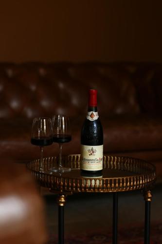 a bottle of wine on a table with two wine glasses at Château Les Oliviers de Salettes in Charols