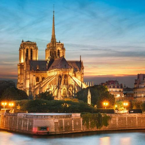 a cathedral with a boat in front of it at BEST CENTRAL Chambres Privées - Seine & Louvre in the Connected Heart of Paris in Paris