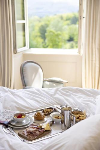 a tray of food on top of a bed at Château Les Oliviers de Salettes in Charols