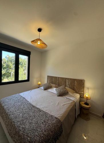 une chambre avec un grand lit avec deux lampes dans l'établissement Appartement paisible au cœur des oliviers, à deux pas de Bonifacio, à Bonifacio