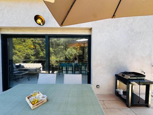 une pièce avec des portes vitrées et une table avec une boîte dessus dans l'établissement Appartement paisible au cœur des oliviers, à deux pas de Bonifacio, à Bonifacio