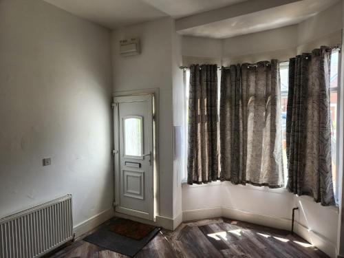 an empty room with a door and windows at Accessible Norton road in Stockton-on-Tees