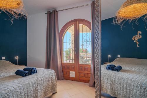 a mirror in a room with two beds and a door at Casa Coromandel in Calpe
