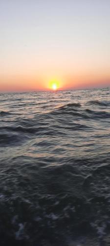a sunset over the ocean with the ocean at Casa orizont in Sulina