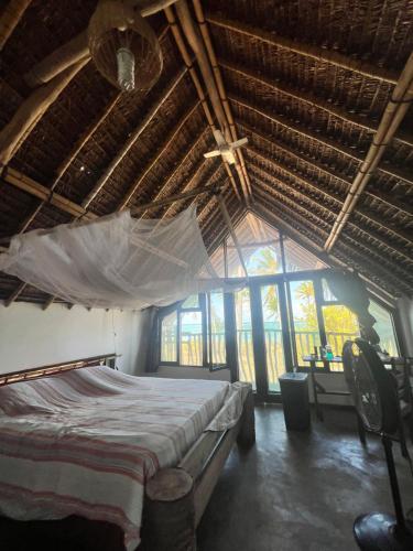 a bedroom with a bed with a mosquito net at Chuiba Palms in Pemba