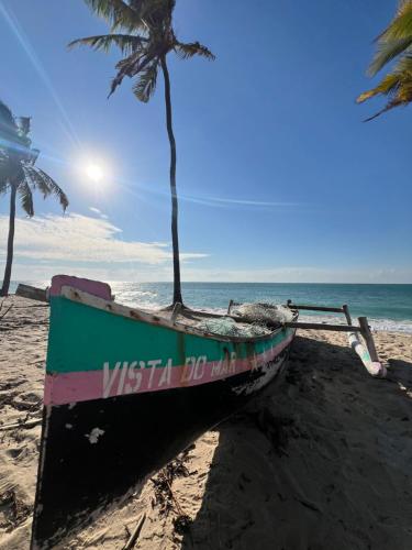 a boat sitting on a beach with a palm tree at Chuiba Palms in Pemba