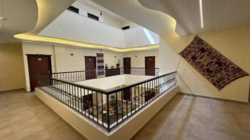 a lobby with a staircase with a rug on the wall at Rumman Hotel in Madaba