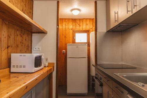 a kitchen with a refrigerator and a microwave at Les Bouviers in Saint-Denis-en-Margeride
