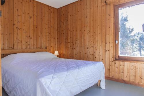 a bedroom with a bed in a wooden wall at Les Bouviers in Saint-Denis-en-Margeride