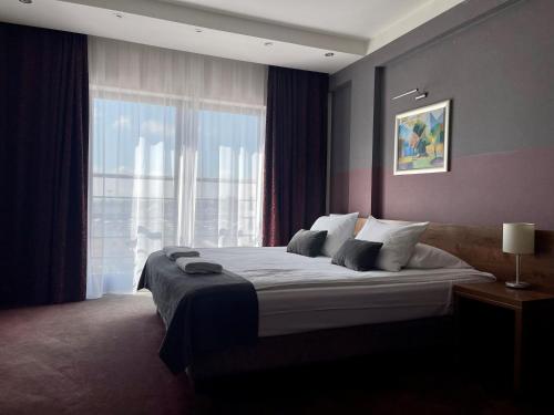 a bedroom with a large bed with a large window at Hotel Swing in Kraków