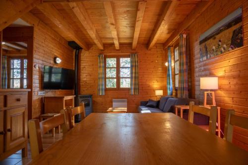 a room with a large wooden table and a couch at Les Bouviers in Saint-Denis-en-Margeride
