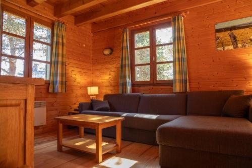 a living room with a couch and a table at Les Bouviers in Saint-Denis-en-Margeride