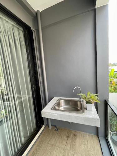 a bathroom with a sink and a window at Luka House in Lam Luk Ka