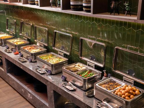 a buffet line with many trays of food at 西安钟楼枫渡酒店永兴坊地铁站店 in Xi'an