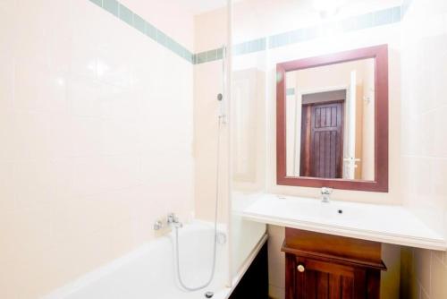 une salle de bain avec un lavabo et un miroir dans l'établissement appartement dans résidence du golf proche du lac, à Biscarrosse