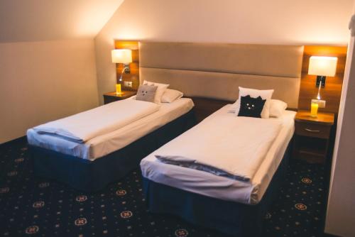 a hotel room with two beds and two lamps at ParkHotel Łysoń in Inwałd