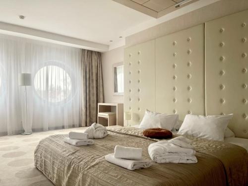 a bedroom with a large bed with towels on it at Hotel Swing in Kraków