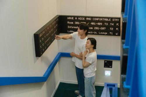 a man and a child standing in front of a sign at Time Terminal Hotel Daejeon 2nd by AanK in Daejeon