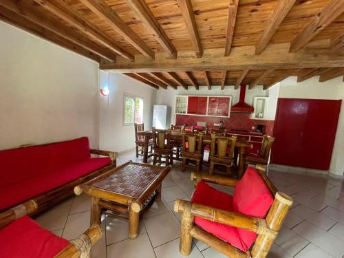 a living room with a red couch and a table at Charming Villa in Foulpointe with Sea View in Foulpointe
