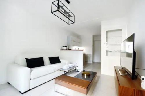 un salon avec un canapé blanc et une table dans l'établissement La Rotonde - Magnifique Appartement climatisé avec parking, à Aix-en-Provence