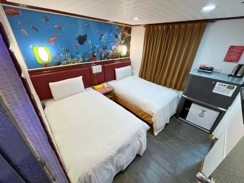 a hotel room with two beds and a fish mural at Dealer Hotel in Taipei