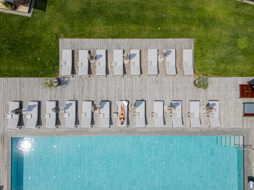 a group of birds sitting on a bench next to a pool at Hotel Weiher Green Lake in Falzes