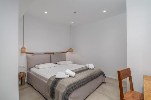 a bedroom with a bed with towels on it at Arco Solium Suites in Adamas