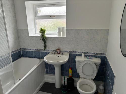 a bathroom with a toilet and a sink and a bath tub at Blyth Royal, Free Parking in Bebside