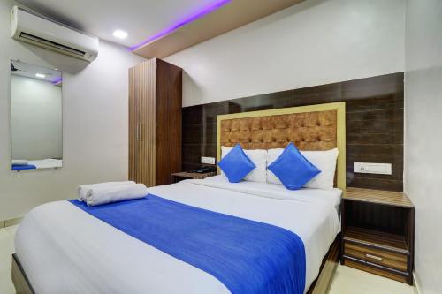 a bedroom with a large bed with blue pillows at Hotel New Blue Sapphire Residency in Mumbai