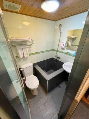 a bathroom with a toilet and a tub and a sink at Dealer Hotel in Taipei