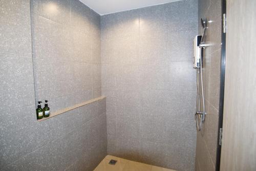 a bathroom with a shower with two bottles of wine at Luka House in Lam Luk Ka