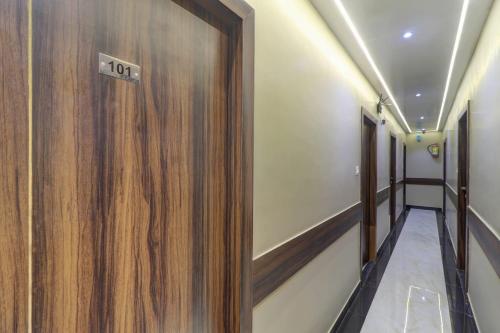 a hallway with a wooden door with a sign on it at Hotel New Blue Sapphire Residency in Mumbai