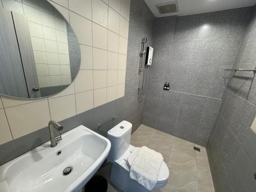 a bathroom with a sink and a toilet and a mirror at Luka House in Lam Luk Ka