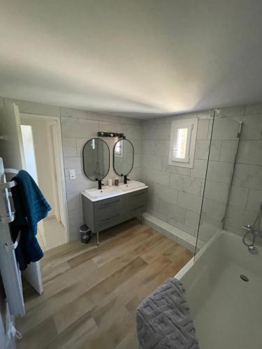 une salle de bain avec une baignoire, un lavabo et un miroir dans l'établissement Bas de villa Hippolyte et Marguerite CLIM, aux Pennes-Mirabeau